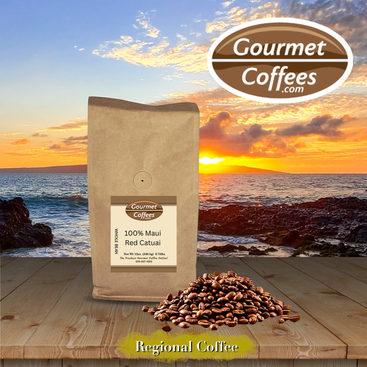 A kraft paper bag of Gourmet Coffees 100% Maui Red Catuai coffee stands on a wooden table with a pile of coffee beans in front, set against a scenic sunset over the ocean.